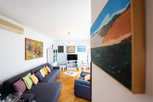 a living room with a blue couch and a painting on the wall at Giorgio - Fontana in Zadar