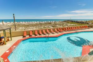 uma piscina com cadeiras e a praia em Phoenix Vacation Rentals em Orange Beach