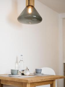 a light hanging over a wooden table with bowls at artHotel Blaue Gans in Salzburg