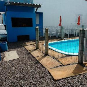 a swimming pool with a fence around it at Residencial Água Azul in Capão da Canoa