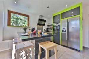 una cocina con encimera negra y detalles verdes en CHEZ LOU ET MAX : UN HAVRE DE PAIX., en Stosswihr