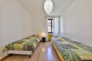 een kamer met 2 bedden en een raam bij CHEZ LOU ET MAX : UN HAVRE DE PAIX. in Stosswihr