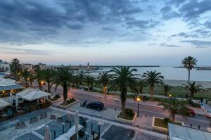Blick auf eine Stadt mit Palmen und das Meer in der Unterkunft Smaragdi Boutique Hotel in Rethymno