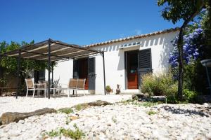 una casa blanca con una mesa y sillas frente a ella en B&B Catedda en Sedilo