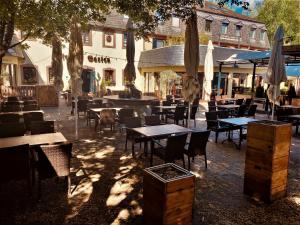 um restaurante ao ar livre com mesas, cadeiras e guarda-sóis em Blesius Garten em Trier