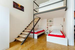 Duas camas e uma escada num quarto com paredes brancas em Rackozi apt em Budapeste