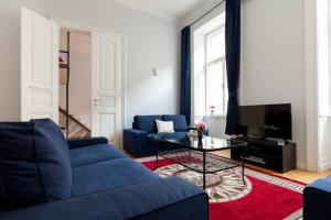 uma sala de estar com um sofá azul e uma mesa em Rackozi apt em Budapeste