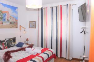 Schlafzimmer mit einem Bett mit roten und weißen Streifen in der Unterkunft Aveiro Central - It´s ALL there in Aveiro