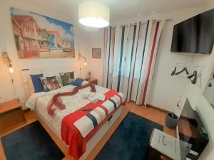 a bedroom with a bed with a red and white blanket at Aveiro Central - It´s ALL there in Aveiro
