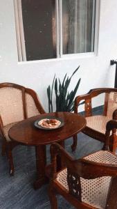 a wooden table with a plate of pizza on it at Sanctuary Cove Guest House in Polonnaruwa