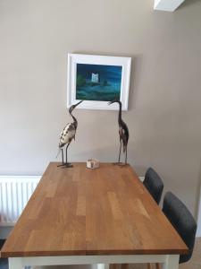 dois pássaros em cima de uma mesa de madeira em The Castle Apartment em Strangford
