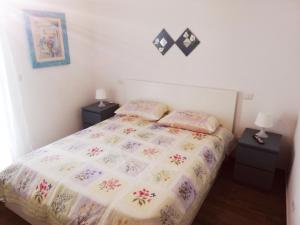 una camera da letto con un grande letto con due comodini di Appartamento PANTA REI 2 a Mola di Bari