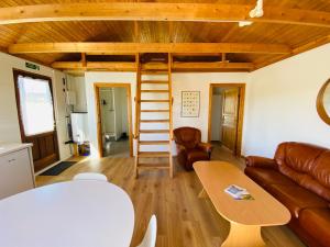 ein Wohnzimmer mit einem Sofa und einem Tisch in der Unterkunft Ábót - Riverside Cottage in Egilsstaðir