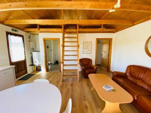 sala de estar con sofá y mesa en Ábót - Riverside Cottage, en Egilsstadir