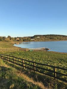 una cerca en un campo junto a un cuerpo de agua en Drumcoura Bungalow, en Leitrim