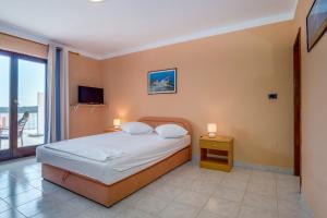 a bedroom with a bed and a balcony with a television at Apartments Villa Julija in Mali Lošinj