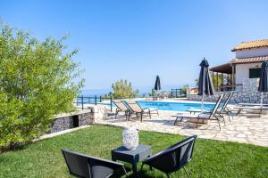 a yard with chairs and a swimming pool at Villa Skyfall in Kalamitsi