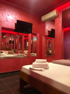 a red room with two beds and a mirror at Spa Secret Apartmani in Belgrade