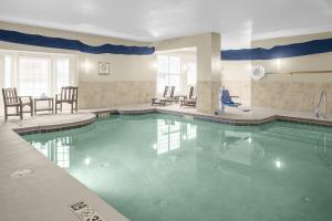 a pool in a hotel with chairs and a table at Staybridge Suites Chattanooga-Hamilton Place by IHG in Chattanooga