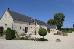 un gran edificio de piedra con un jardín delante de él en Les Pérelles en Saint-Vigor-le-Grand