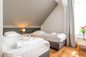 two beds in a room with a attic at Pensiunea Armonia in Nădăşelu