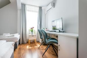 a bedroom with a desk with a computer and a bed at Pensiunea Armonia in Nădăşelu
