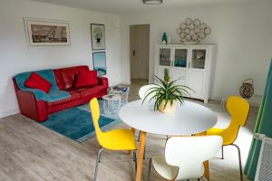 a living room with a table and yellow chairs at Fehmarn Relax in Burg auf Fehmarn