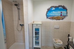 uma casa de banho com um chuveiro e um WC. em Fehmarn Relax em Burg auf Fehmarn