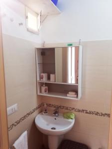 ein Bad mit einem Waschbecken und einem Spiegel in der Unterkunft Appartamento PANTA REI 1 in Mola di Bari