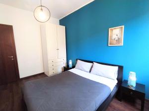 ミラノにあるParsifal Apartmentの青い壁のベッド付きの青いベッドルーム1室