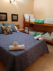 アラウリン・デ・ラ・トレにあるHostal El Patioのベッドルーム1室(二段ベッド2台、ベッド1台にタオル付)