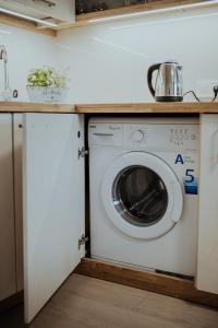 uma máquina de lavar roupa debaixo de um balcão numa cozinha em Lina apartamenti em Jūrkalne