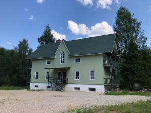 a white house with a green roof at Metsalagendik Apartments in Otepää