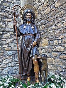 a statue of a man with a dog in front of a wall at Hospedaje Octavio in Santillana del Mar