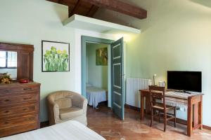 a bedroom with a bed and a desk and a computer at Cascina Scanna in Cisliano