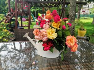 eine weiße Vase voller Blumen auf dem Tisch in der Unterkunft Villa Victoria in Mosonmagyaróvár