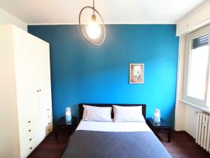 ein blaues Schlafzimmer mit einem Bett und einer blauen Wand in der Unterkunft Parsifal Apartment in Mailand