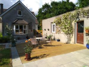 eine Terrasse mit einem Tisch und Stühlen vor einem Haus in der Unterkunft Twin Oaks Bed & Breakfast in Kilkenny