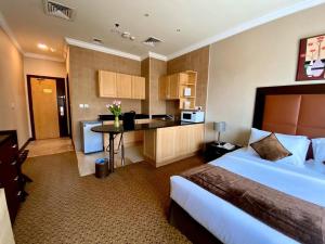 a hotel room with a bed and a kitchen at Kingsgate Hotel Doha by Millennium Hotels in Doha