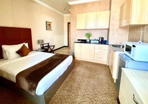 a hotel room with a bed and a kitchen at Kingsgate Hotel Doha by Millennium Hotels in Doha