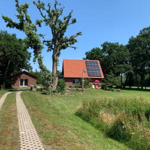 een huis met een rood dak en een zonnepaneel bij Ferienhaus Jahn in Barßel