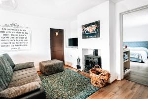 a living room with a couch and a fireplace at The Lodge in Walberswick