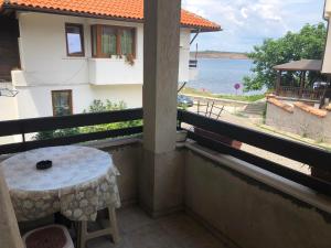 einen Balkon mit einem Tisch und Blick auf das Wasser in der Unterkunft Guest House Liliya in Sozopol