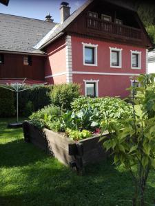 un jardín frente a una casa roja en La vecchia Mesnerhaus, en Pusterwald