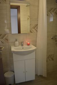 a bathroom with a white sink and a mirror at Casa DODÓ Vendégház in Praid
