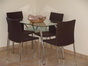 a glass table with chairs and a bowl of fruit on it at Enalia Gi in Límni