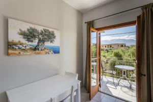 a room with a table and a balcony with a view at Lefkis apartments & studios in Stoupa