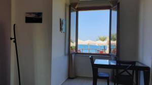 a room with a table and a view of the ocean at Cala Dei Mori in Livorno