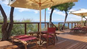 a deck with chairs and tables and an umbrella at Cala Dei Mori in Livorno