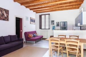 a living room with a table and a purple couch at Cascina Scanna in Cisliano